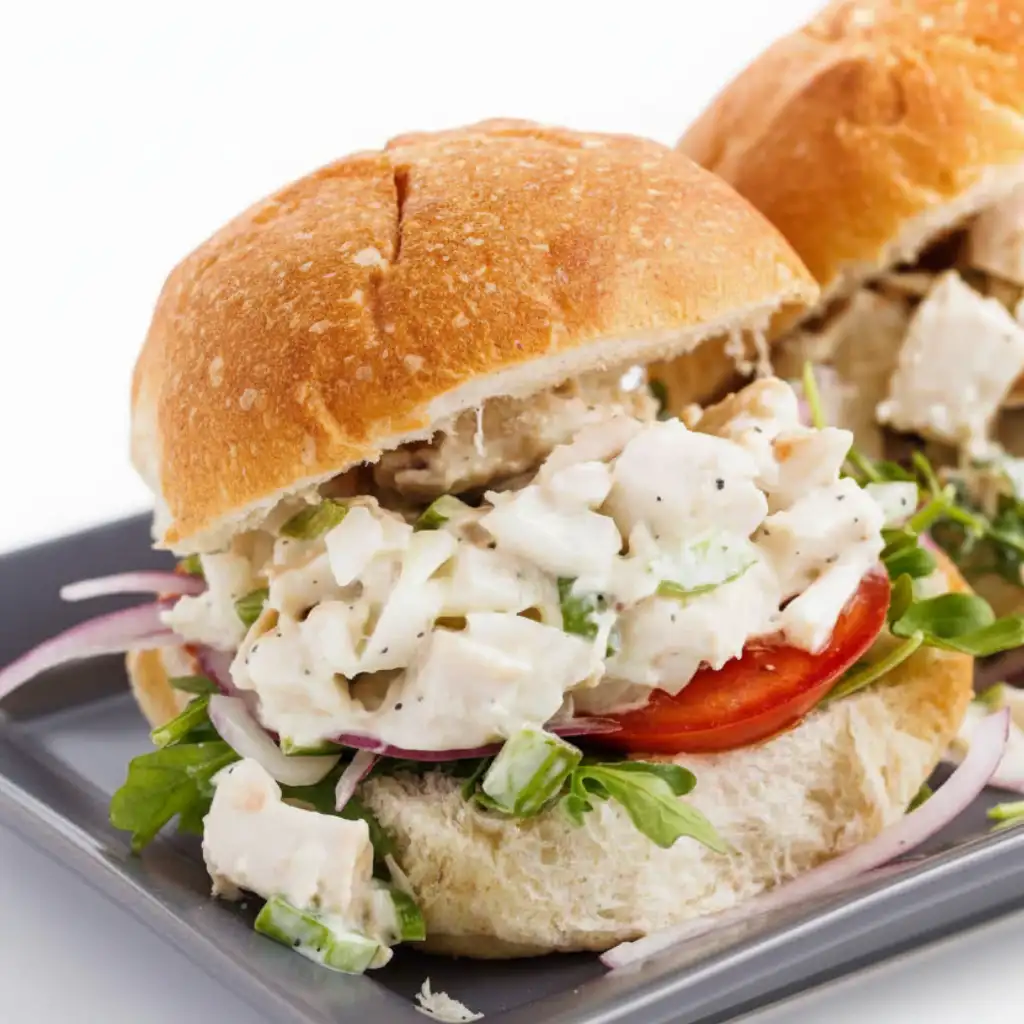 Chicken salad sliders with fresh veggies on soft buns.